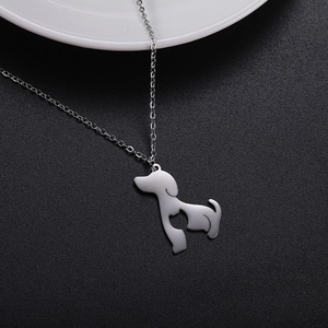 Macro shot of silver dog pendant necklace with hollow heart detail on black background