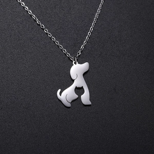 Silver hollow cat and dog silhouette pendant necklace on dark textured surface