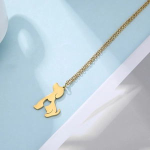 Close-up of golden hollow dog pendant featuring a minimalist poodle silhouette design