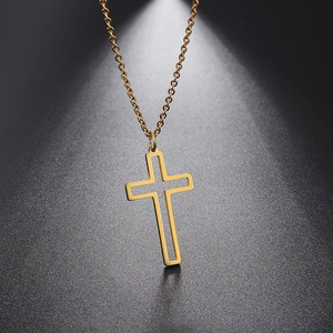 Close-up of golden hollow cross pendant with O-chain on dark textured background