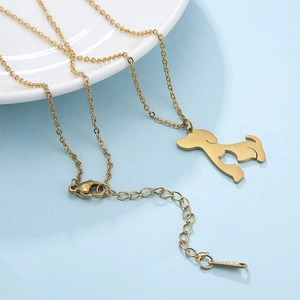 Detailed close-up of a golden dog pendant necklace with lobster clasp and extension chain