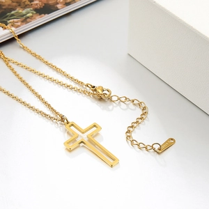 Detailed close-up of hollow cross pendant with gold plating and lobster clasp closure