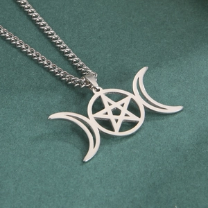 Détail du collier avec pendentif triple lune et pentagramme sur fond vert foncé