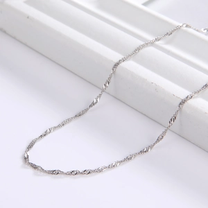 Detail of silver water wave chain necklace texture with elegant metallic luster on white background