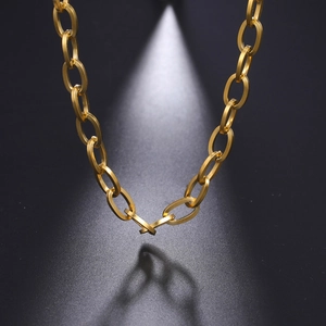 Makroaufnahme der mattgoldenen Halskette mit ovalen Gliedern und Spotlicht-Effekt