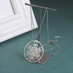 Vue détaillée du pendentif cube de Métatron argenté avec motifs géométriques creux