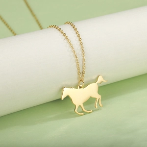 Close-up of a polished gold-colored pony silhouette pendant necklace on a white display stand