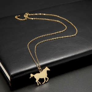 Detailed view of a gold horse pendant necklace on a premium black leather texture background