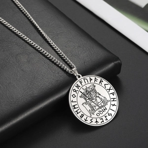Detailed macro view of Odin pendant with Viking runes and heavy Cuban link chain