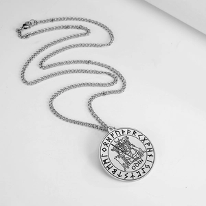Macro shot of silver stainless steel Odin pendant with Norse Runes on a thin cable chain
