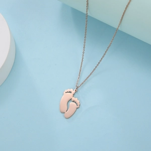 Detail of rose gold 304 stainless steel necklace with double baby footprint pendants
