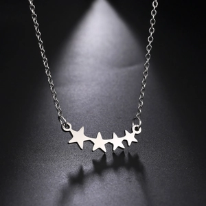 Macro-opname van vier gepolijste zilveren sterhangers aan een fijne schakelketting