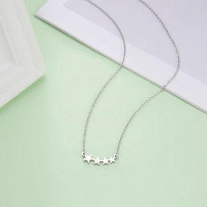 Detail van zilveren titanium stalen ketting met vier stervormige hangers aan fijne ketting