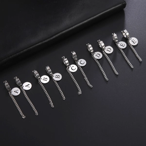 Détail de boucles d'oreilles lettres en acier argenté avec créoles et chaînes