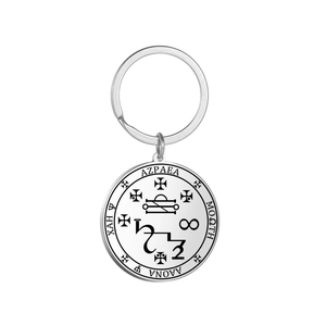 Macro view of occult symbols and mystic engraving on stainless steel round keychain