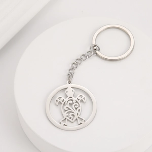Detailed close-up of a silver stainless steel keychain featuring a hollow sea turtle design