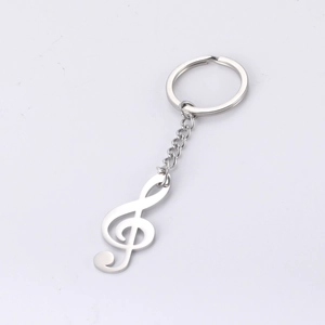 Detailed view of polished stainless steel treble clef pendant keychain on white background