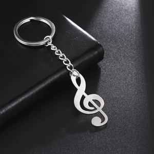 Polished stainless steel G-clef musical note keychain for car keys on leather surface