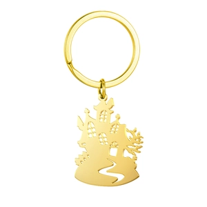 Detailed close-up of a hollowed-out golden haunted house keychain with spooky silhouettes