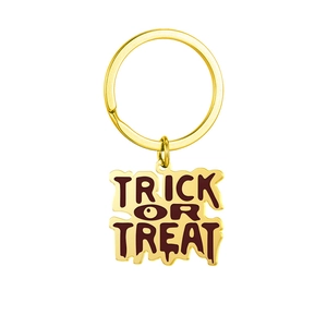 Détail d'un porte-clés doré Trick or Treat avec bords texturés et lettrage gravé de fête