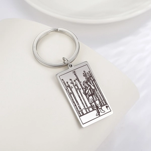 Détail macro du porte-clés en acier inoxydable avec gravure de tarot Neuf de Bâton