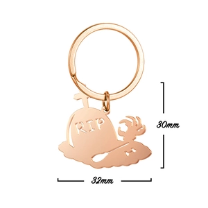 Close-up of rose gold Halloween keychain featuring RIP gravestone and skeleton claw