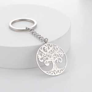 Polished stainless steel keychain with hollow tree of life pendant on a minimalist stand