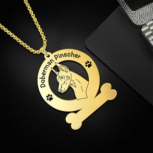 Detailweergave van een gouden Dobermann Pinscher hanger met botontwerp en gravering