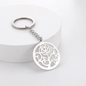Hollow rose and leaf pattern stainless steel keychain on white display stand