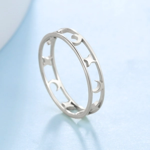 Anillo de acero inoxidable plateado con patrones calados de estrellas y lunas