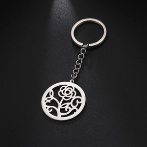 Detail of silver stainless steel keychain with intricate hollow rose flower round pendant