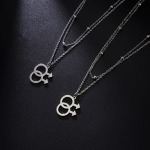 Detail of double male symbol pendant on tiered beaded chain with polished steel finish