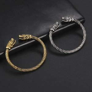 Dettaglio di bracciali Viking con testa di lupo in finiture oro e argento anticato