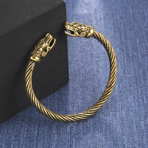 Dettaglio macro del bracciale vichingo oro retrò con doppie teste di animali e trama a corda