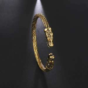 Dettaglio del bracciale vichingo dorato con teste di drago doppie finemente intagliate