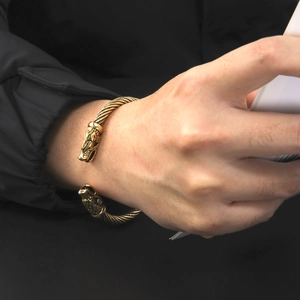 Dettaglio del bracciale rigido aperto con testa di lupo vintage e design a corda intrecciata