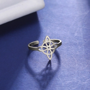 Macro shot of silver adjustable titanium steel ring with hollow geometric petal patterns