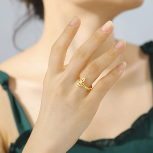 Adjustable gold titanium steel ring with hollow four-petal leaf design on female hand