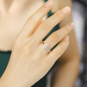 Close-up of adjustable silver titanium steel ring with hollowed four-leaf design on hand