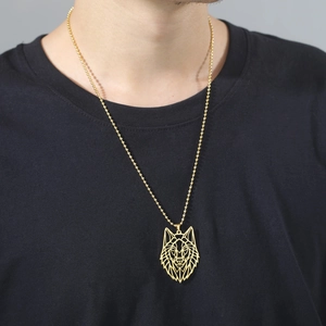 Detail of golden geometric hollow wolf head pendant on a stainless steel bead chain