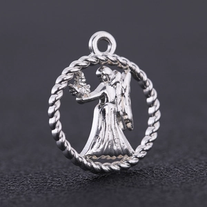 Macro shot of silver zodiac charm featuring a winged female figure in a rope border