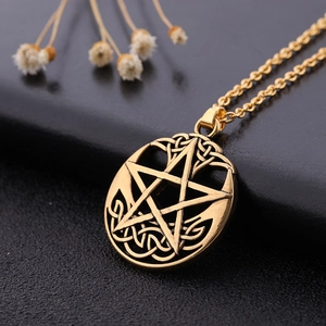 Detailed close-up of golden pentagram pendant with intricate Celtic knot engraving