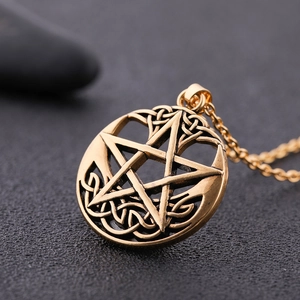 Macro shot of gold Celtic knot pentagram pendant with vintage textured metal details