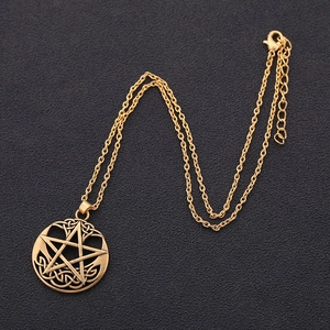 Detailed macro view of the gold pentagram pendant with intricate Celtic knot patterns