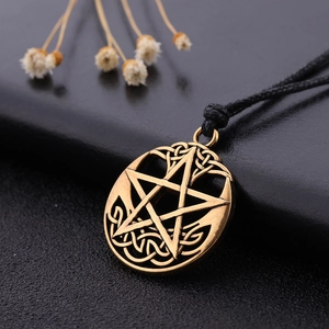 Detailed macro view of vintage bronze pentagram pendant with Celtic knot on black cord