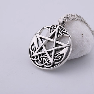 Close-up of vintage silver pentagram pendant with intricate Celtic knot patterns