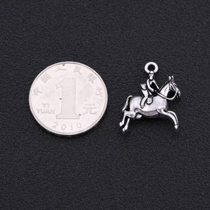 Vue détaillée d'un pendentif cheval argenté vintage avec référence de taille à côté