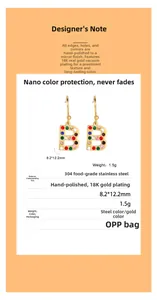 Gros plan sur une boucle d'oreille B dorée avec strass colorés en acier plaqué or 18K