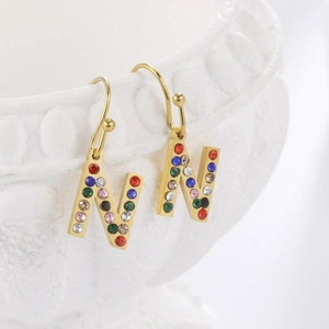 Vue détaillée de boucles d'oreilles lettre N dorées avec des zircons multicolores