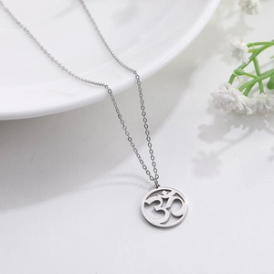 Primer plano del collar con colgante de símbolo Om plateado y diseño circular sobre blanco